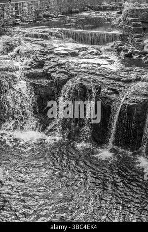 Gayle Beck si tuffa sulle formazioni rocciose in una tranquilla piscina ondulata, Hawes, Yorkshire, Regno Unito. Foto Stock