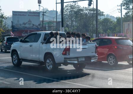 Un camion aperto che trasporta lavoratori su una strada trafficata a Chiang Rai nel nord della Thailandia Foto Stock