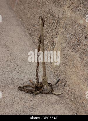 vecchio ancoraggio arrugginito con catena. Spedire una vite ancorata sul lungomare Foto Stock