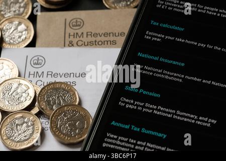Schermata dell'app HMRC che mostra le opzioni di assicurazione nazionale, pensione statale e riepilogo fiscale insieme a monete in sterline e documenti ufficiali, Stafford, United King Foto Stock