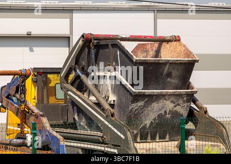 Contenitore in metallo a doppio scarico a salto utilizzato per lo smaltimento di materiali di scarto scavati nell'industria edile all'esterno su strada Foto Stock