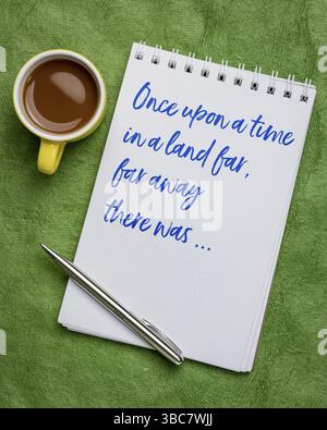 C'era una volta in una terra lontana - una frase per aprire narrazioni orali, storie o fiabe scritte a mano in un bozzetto d'arte con una tazza di caffè Foto Stock