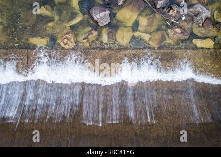 Diga di deviazione dell'acqua su un fiume di montagna - vista aerea dall'alto Foto Stock