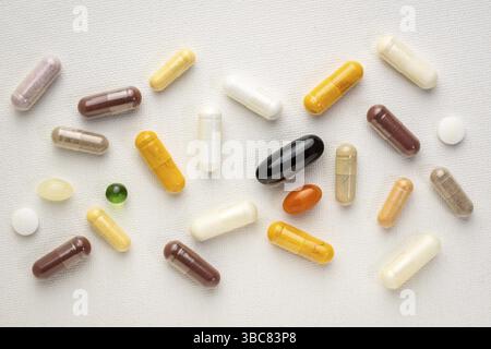 Vitamine e supplementi sfondo - pillole, capsule e compresse su una tela bianca d'arte, assistenza sanitaria, cura di sé e concetto di benessere Foto Stock
