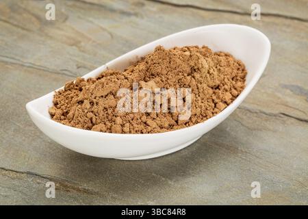Una piccola ciotola in ceramica di polvere di cacao organico grezza ricca di antiossidanti e magnesio Foto Stock