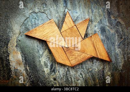 Immagine astratta di un pipistrello volante costruito con sette pezzi di legno tangram su uno sfondo di ardesia, Halloween Concept, opera d'arte creata dalla foto Foto Stock