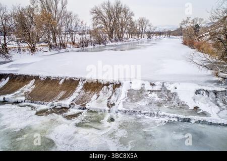Una delle numerose dighe di diversione d'acqua sul fiume Poudre - vista aerea del paesaggio invernale Foto Stock