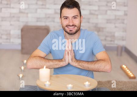 uomo sportivo e consapevole che meditava da solo a casa Foto Stock