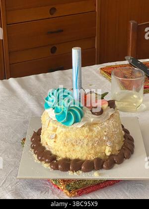 Torta di compleanno rotonda millefoglie decorata con meringa, crema al cioccolato, fragole e una candela su una tovaglia bianca a Pescara, Abruzzo, Italia Foto Stock