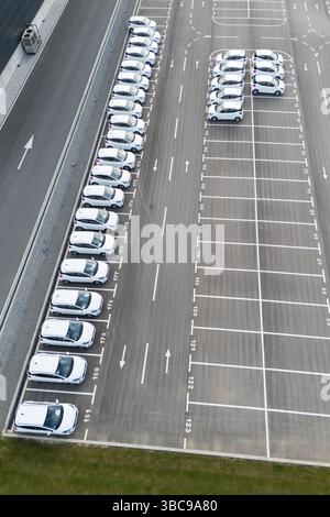 Flotta di veicoli per il merchandising parcheggiata accanto a un centro logistico. Vista aerea. Foto Stock