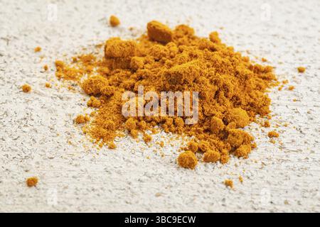 Polvere di curcuma su una superficie in legno grezzo verniciata di bianco Foto Stock