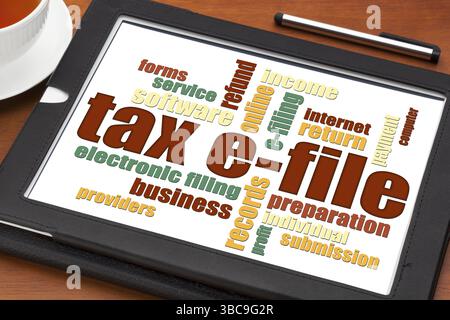 Concetto di archiviazione elettronica fiscale - una parola cloud su un tablet digitale con una tazza di tè Foto Stock