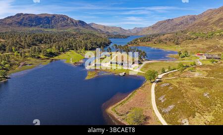 Glen Affric Cannich Scotland un cielo blu sopra il Loch Lodge e annessi con molti alberi in una giornata di sole a Springtime Foto Stock
