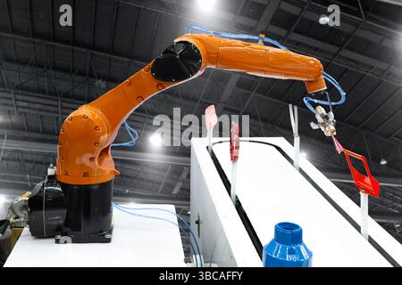Spray per verniciatura braccio robotizzato sulla parte automobilistica. Concetto di produzione ad alta tecnologia. (con tracciato di ritaglio) Foto Stock