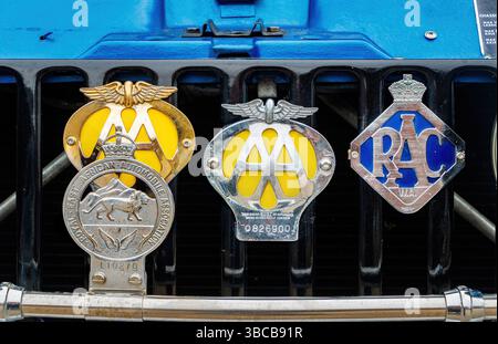 Primo piano dei badge vintage cromati AA e RAC sulla parte anteriore di una Range rover vintage blu Foto Stock
