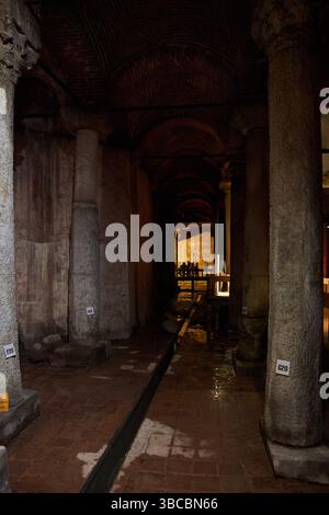 Antica Cisterna Basilica, Istanbul. Passaggio poco illuminato con colonne in pietra, soffitti ad arco e passerella turistica Foto Stock