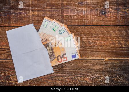 50 le banconote in euro sono collocate in una busta aperta sulla tavola. La moneta dell'Unione europea Foto Stock