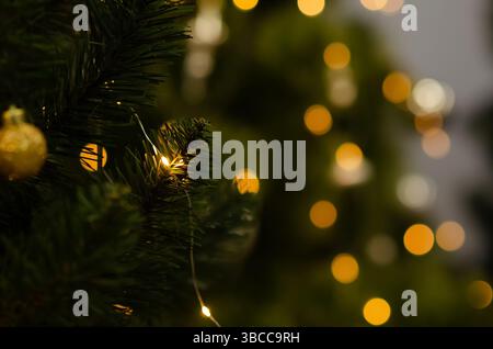 Decorazioni natalizie morbide con spazio per copie. Concetto di vacanza invernale stagionale. Tradizionale albero di Natale artificiale con luci della ghirlanda e glowi Foto Stock