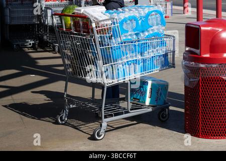Un'auto per lo shopping carica di acqua in bottiglia di Kirkland, uova e altri articoli acquistati in un negozio Costco a New Orleans, Louisiana. Foto Stock