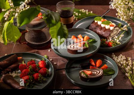 Deliziosi panini svizzeri al cioccolato e fragole fresche elegantemente disposte su piatti, accompagnati da bicchieri di caffè ghiacciato, per creare un dessert allettante Foto Stock