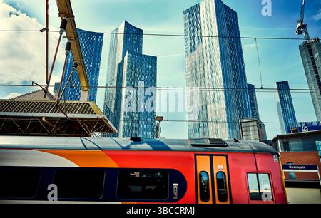 Alti edifici nel centro di Manchester. Treno alla stazione di Deansgate con sfondo grattacielo Foto Stock
