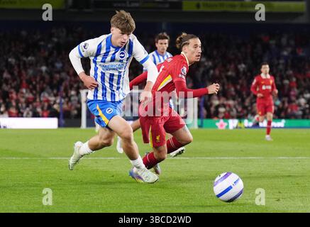Harry Howell di Brighton e Hove Albion e Kostas Tsimikas di Liverpool (destra) combattono per il pallone durante la partita di Premier League all'American Express Stadium di Brighton. Data foto: Lunedì 19 maggio 2025. Foto Stock