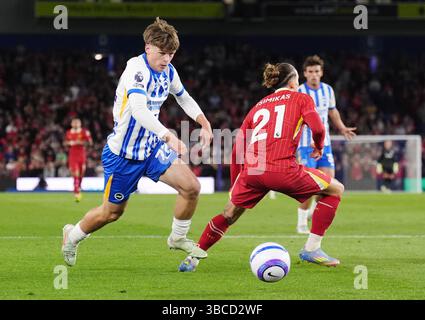 Harry Howell di Brighton e Hove Albion e Kostas Tsimikas di Liverpool (destra) combattono per il pallone durante la partita di Premier League all'American Express Stadium di Brighton. Data foto: Lunedì 19 maggio 2025. Foto Stock