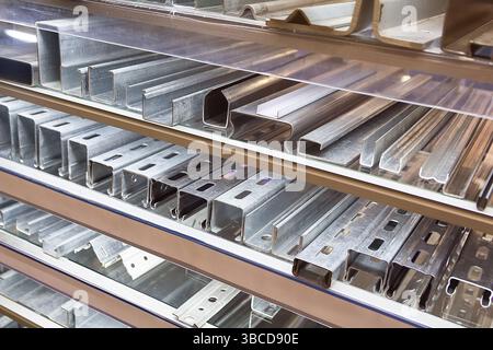Una varietà di profili in alluminio sulla vetrina di un negozio di costruzioni. Industria Foto Stock
