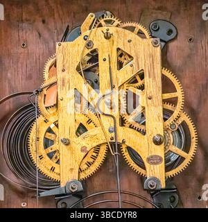 Primo piano del meccanismo interno in legno e ottone di un orologio antico, che mostra l'artigianato dettagliato e l'ingegneria storica. Foto Stock