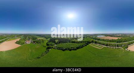 Hallerbos, Halle, Vlaams Brabant, Belgio, 27 aprile, 2025, Una splendida vista aerea mostra i vibranti campi agricoli bagnati dalla luce del sole sotto un cielo azzurro Foto Stock
