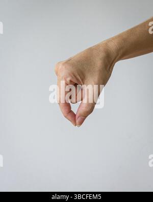 La mano della donna forma un gesto di avvicinarsi per pizzicare qualcosa. Isolato su sfondo bianco. Foto Stock