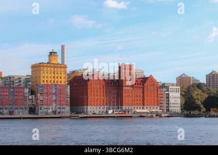 Edifici colorati sul lungomare, tra cui l'iconico Münchenbryggeriet in mattoni rossi e lo storico edificio giallo della fabbrica Södra Teatern a Södermalm Foto Stock