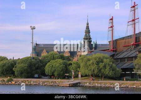 Il Museo nordico (Nordiska museet) e gli alberi delle navi del Museo Vasa visti dall'altra parte dell'acqua a Djurgården, Stoccolma, Svezia, durante una serata estiva. Foto Stock
