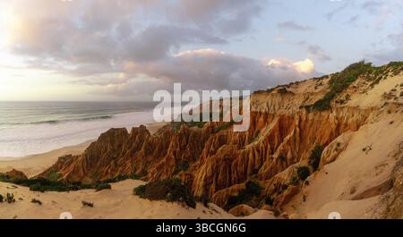 Molte bizzarre dune di sabbia erose sull'Oceano Atlantico con onde che si infrangono al tramonto Foto Stock