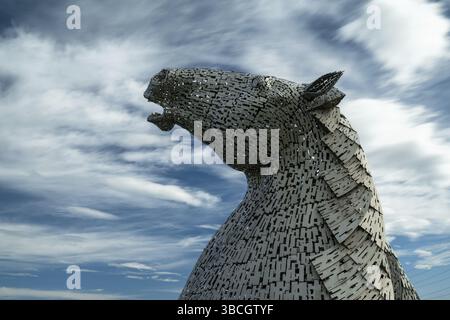 Falkirk, Regno Unito - 20 Giugno, 2022: Una delle sculture a testa di cavallo Kelpies con un cielo espressivo a lunga esposizione alle spalle Foto Stock