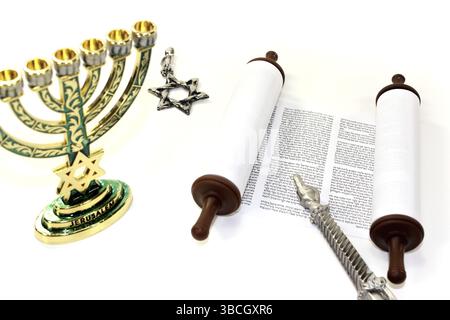 Rotolo della Torah con menorah, Stella di Davide e puntatore della Torah su uno sfondo di colore chiaro Foto Stock