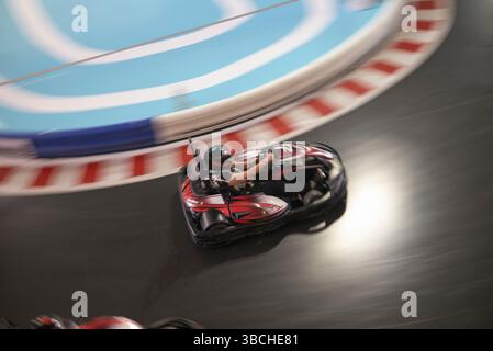 Persona che guida un go-kart su una pista da corsa con sfondo sfocato che indica la velocità. Abu Dhabi, Emirati Arabi Uniti Foto Stock