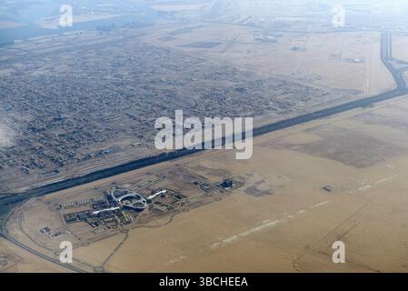 Vista aerea dei paesaggi urbani e desertici che mostra un confine distinto tra terra sviluppata e arida. Abu Dhabi, Emirati Arabi Uniti Foto Stock