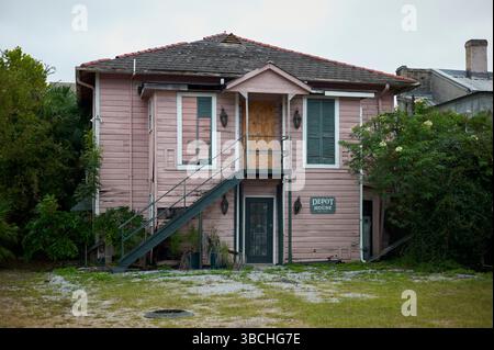 Edificio rustico in legno a due piani con una finestra a bordo e lussureggiante vegetazione che lo circonda. New Orleans, Louisiana, Stati Uniti Foto Stock