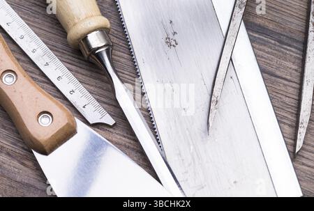 La foto mostra diversi attrezzi usati su un tavolo di legno Foto Stock