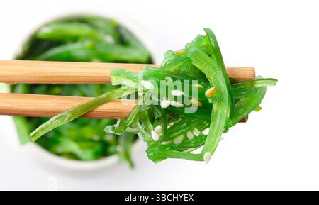 Bacchette con insalata di alghe giapponesi. Cucina Giapponese - insalata Wakame, insalata di alghe Chuka Foto Stock