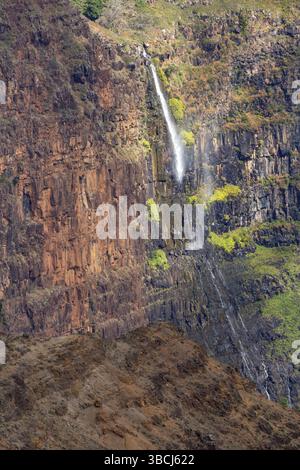 Piccola cascata su una parete rocciosa verticale alle Hawaii Foto Stock
