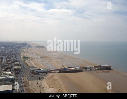 Una vista aerea della spiaggia di blackpool che guarda a nord mostrando i moli sud e centrale con la bassa marea con la strada principale e la città che si estendono all'orizzonte Foto Stock