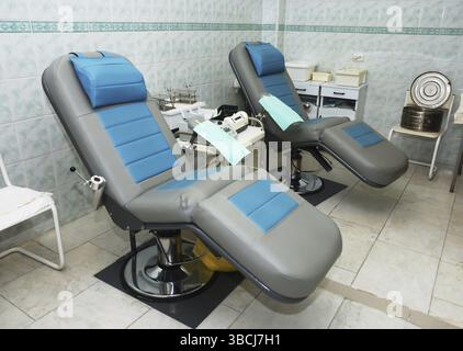 Due poltrone e apparecchi medici per donatori di sangue in sala operatoria Foto Stock