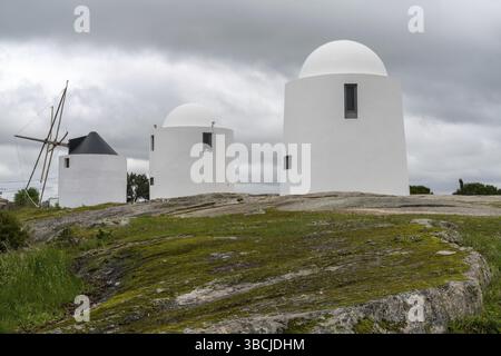 Evora, Portogallo - 24 marzo 2022: I mulini a vento di Sao Bento di Evora sotto un cielo sovrasparato espressivo Foto Stock
