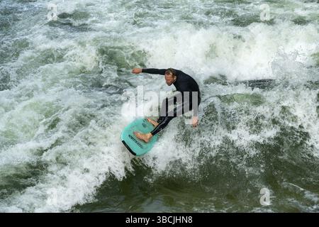 Germania - 17 settembre 2020: Uomo che naviga sull'onda stazionaria sul torrente Eisbach nel centro di Monaco Foto Stock