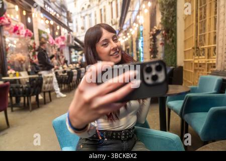 Influencer che crea contenuti per i social media in un bar alla moda Foto Stock