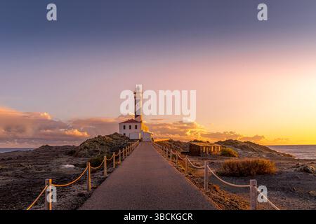Faro di Cap de Favaritx sull'isola di Minorca a nord-est di Mahon, Isole Baleari della Spagna. L'alba è bellissima, con il faro e lo stupin Foto Stock