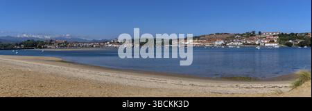 San Vicente de la Barquera, Spagna - 25 aprile 2022: Vista panoramica della spiaggia di Maza e di San Vicente de la Barquera con i monti Picos de Europa nel b Foto Stock