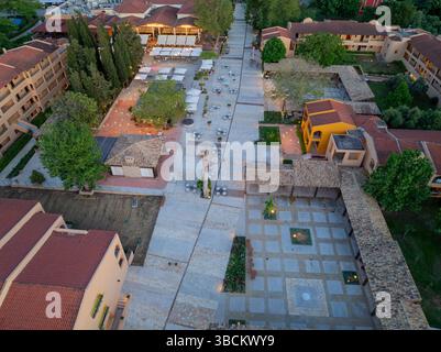 Veduta aerea che mostra un'affascinante piazza mediterranea della città, inondata di luce soffusa al crepuscolo. Foto Stock